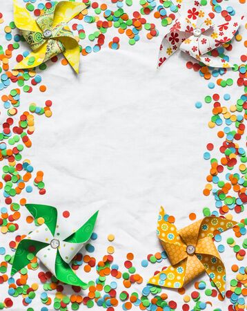 Celebration background with colorful confetti and homemade paper fans, light background, top view. Free space for textの写真素材