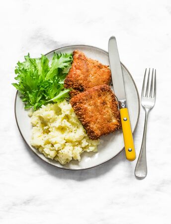 Comfort food - deep-fried fish and buttery mashed potatoes on a light background, top viewの写真素材
