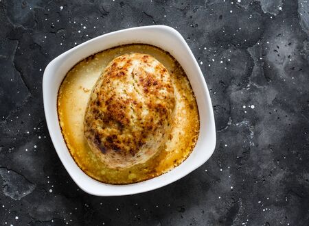 Chicken baked meatloaf in a baking dish on a dark background, top viewの写真素材