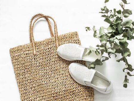 Eco bag made of straw, sport shoes on a white background, top view. Shopping walking conceptの写真素材