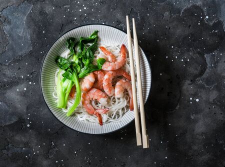 Rice noodles with poached shrimp and bok choy cabbage on a dark background, top viewの写真素材