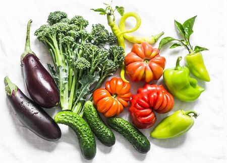 Aubergines, tomatoes, peppers, broccoli on a light background, top view. Flat lay, copy space. Healthy food conceptの写真素材
