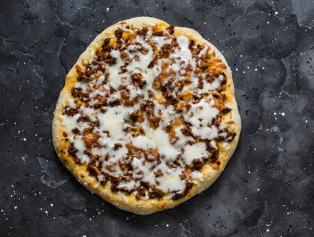 Spicy ground beef, tomato sauce, mozzarella pizza on a dark background, top viewの写真素材