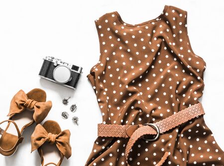 Summer dress with polka dots without sleeves, suede wedge sandals, earrings, camera on a light background, top view. Women's clothing beauty conceptの写真素材