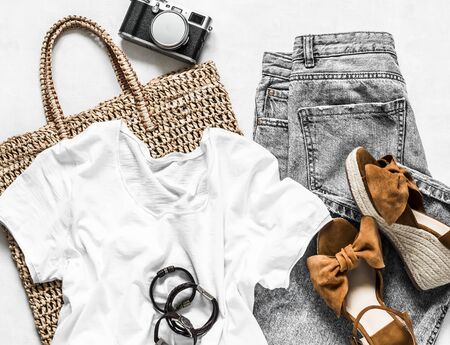 Women's clothing summer - grey mom's jeans, suede brown wedge sandals, white cotton t-shirt, eco bag straw, camera on a light background, top viewの写真素材