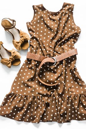 Polka dot brown sleeveless summer dress and suede wedge sandals on a light background, top view. Fashion conceptの写真素材