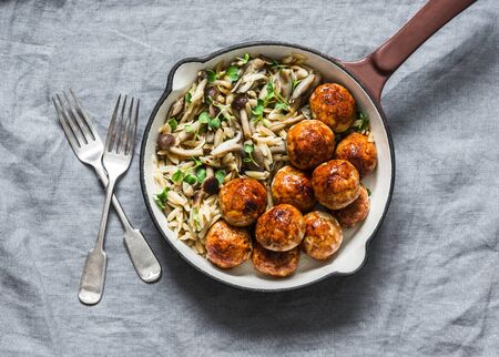 Orzo mushrooms pasta with teriyaki sauce chicken baked meatballs in a pan on a gray background, top viewの写真素材