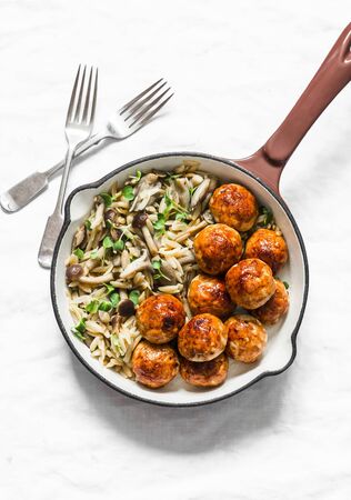 Orzo mushrooms pasta with teriyaki sauce chicken roasted meatballs in a pan on a light background, top viewの写真素材