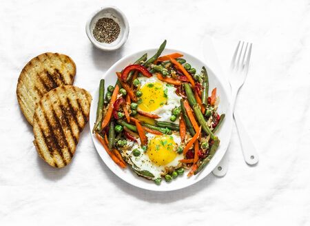Eggs vegetable stir fry asian style shakshuka on a light background, top view. Delicious healthy breakfast, lunchの写真素材