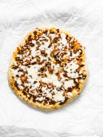 Spicy ground beef, tomato sauce, mozzarella pizza on a light background, top viewの写真素材