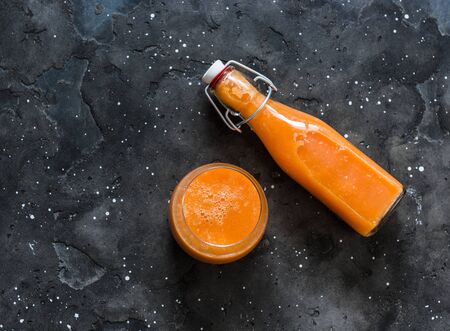 Magic mango smoothies - smoothies with ripe mango, carrot, orange, honey, ginger on a dark background, top view. Detox drinkの写真素材