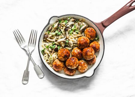 Orzo mushrooms pasta with teriyaki sauce chicken roasted meatballs in a pan on a light background, top viewの写真素材