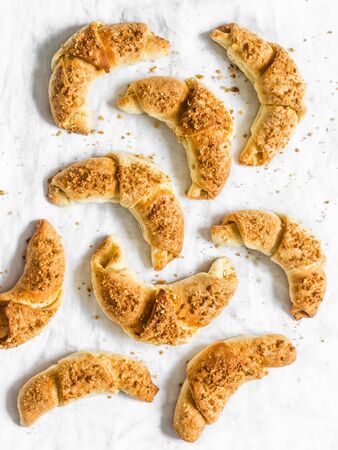 Homemade puff pastry croissants with walnut and brown sugar filling on a light background, top viewの写真素材
