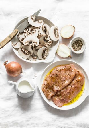 Ingredients for cooking fried chicken fillet with cheesy mushrooms cream sauce on a light background, top view. Delicious homemade lunchの写真素材