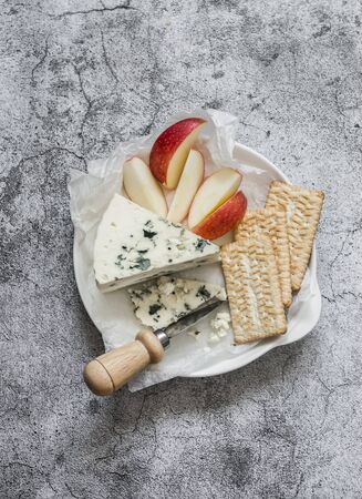 Delicious snack - cracker cookies, apple and gorgonzola cheese on a grey background, top viewの写真素材