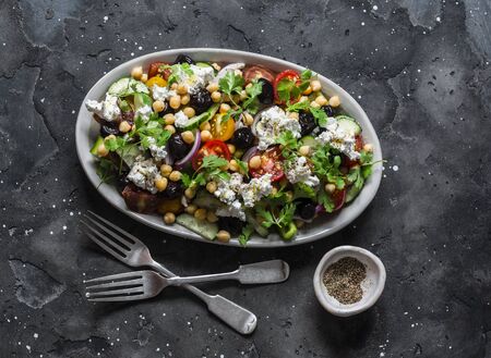 Classic Greek salad with chickpeas on dark background, top view. Vegetarian healthy diet foodの写真素材