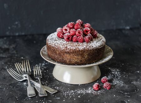 Delicious chocolate fresh raspberry sponge cake on dark background. Tasty dessertの写真素材