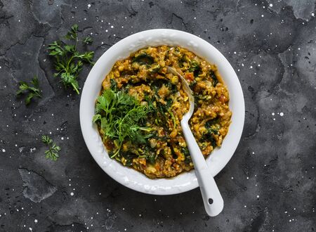 Aubergine spinach vegetarian indian curry on a dark background, top view. Indian cuisineの写真素材