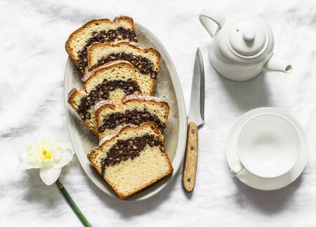 Homemade buttery cake with chocolate nut streusel, tea set on a light background, top viewの写真素材