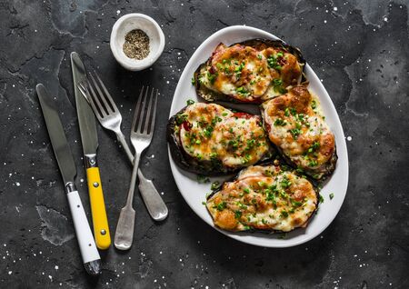 Baked eggplant with ham, tomatoes and mozzarella - delicious appetizer, tapas on a dark background, top viewの写真素材