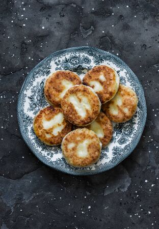 Syrniki - delicious breakfast, snack on a dark background, top view. Cottage cheese pancakesの写真素材