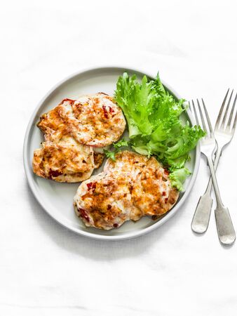 Roasted chicken chop with tomatoes, mushrooms and mozzarella on a light background, top view. Delicious healthy lunchの写真素材