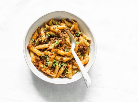 Vegetarian lentil Bolognese sauce with penne pasta on a light background, top view. Healthy eating diet concept foodの写真素材