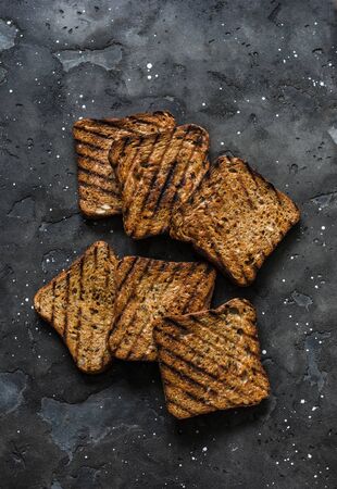 Whole grain seeds grilled toast bread for sandwiches on a dark background, top viewの写真素材