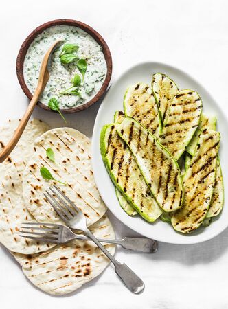 Grilled zucchini, flatbread and greek tzadziki sauce - delicious  snack, tapas, appetizers on a light background, top viewの写真素材