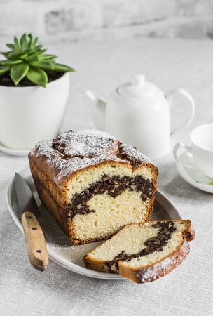 Cozy tea table - homemade cake with nuts and chocolate, teapot, cup, succulent flower on the kitchen tableの写真素材