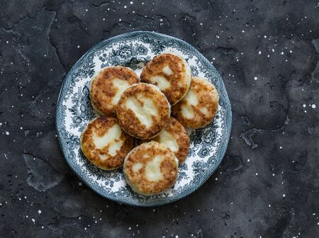 Syrniki - delicious breakfast, snack on a dark background, top view. Cottage cheese pancakesの写真素材
