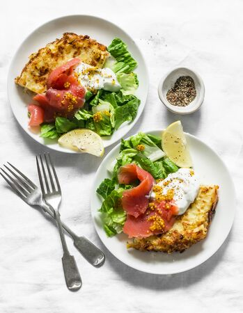 Potato tortilla frittata with natural greek yogurt, smoked salmon and green salad on a light background, top view. Delicious breakfast, appetizer, tapasの写真素材