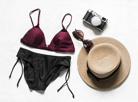 Women's bikini, hat, camera on a light background, top view. Vacation beach fashion conceptの写真素材