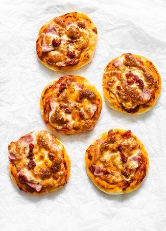 Ham, tomato sauce, mozzarella pizza on a light background, top view. Delicious breakfast, snack, tapasの写真素材