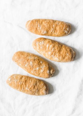 Homemade whole grain hot dogs rolls on a light background, top view. Buns for sandwichesの写真素材