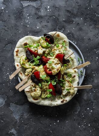 Vegetarian vegetables skewers with mushrooms, peppers, zucchini and naan flatbread on a dark background, top view. Delicious tapasの写真素材
