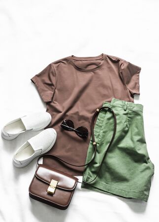 Women's cotton bermuda shorts, brown t-shirt, cross body bag, white sneakers on a light background, top viewの写真素材