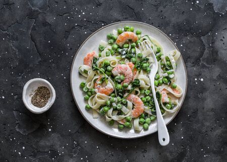 Green peas, shrimps, spinach, cream sauce tagliatelle pasta  on a dark background, top view. Mediterranean food styleの写真素材