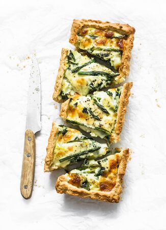 Tart with asparagus, mozzarella and spinach on a light background, top viewの写真素材