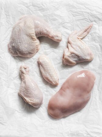 Pieces of raw butchered chicken - legs, thighs, breast, wing on a light background, top viewの写真素材