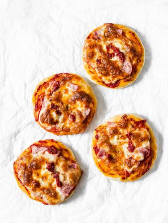 Ham, tomato sauce, mozzarella, sun dried tomatoes pizza on a light background, top view. Delicious tapasの写真素材
