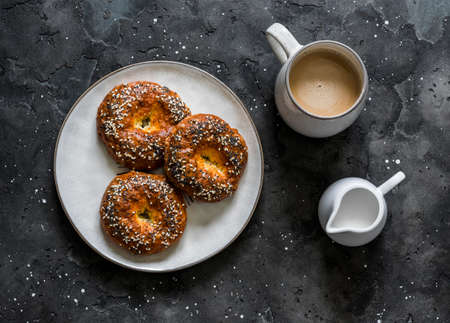 Savory cheese buns and coffee with cream on a dark background, top view. Delicious breakfast, brunchの写真素材