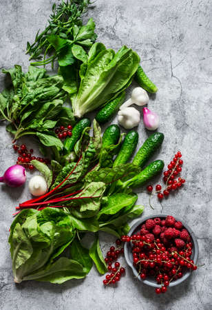Fresh organic garden products - seasonal herbs, vegetables and berries on a gray background, top viewの写真素材