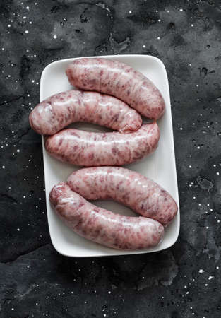 Raw uncooked turkey homemade sausages on dark background, top view. Food ingredientの写真素材