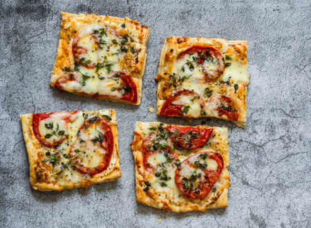 Delicious tapas, appetizers, snack - organic tomatoes, fresh thyme, mozzarella pizza on a gray background, top viewの写真素材