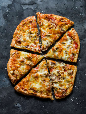 Canned tuna, tomatoes, mozzarella cheese puff pastry pizza on a dark background, top view. Delicious tapas, appetizersの写真素材