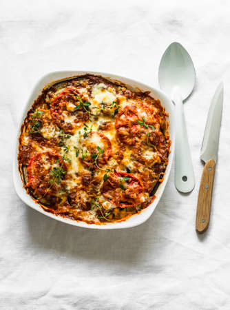 Eggplant, chicken, tomatoes, mozzarella cheese, tomato sauce casserole on a light background, top viewの写真素材