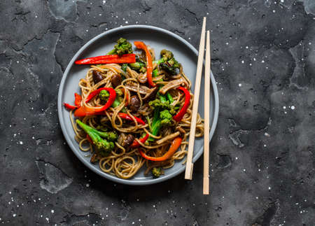 Vegetarian lunch - noodles with vegetable stir fry teriyaki sauce on a dark background, top view. Asian style foodの写真素材