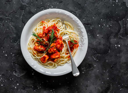 Rosemary chicken tomato sauce chili pepper spaghetti on a dark background, top view. Delicious lunchの写真素材
