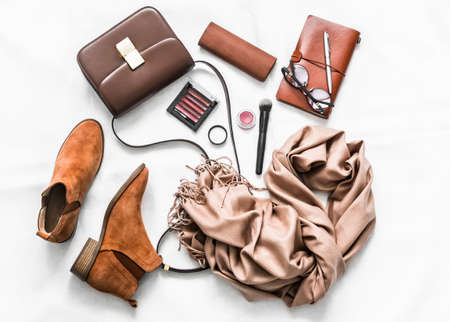 Suede shoes, cashmere scarf, bag, cosmetics, organizer on a light background, top view. Fashion conceptの写真素材